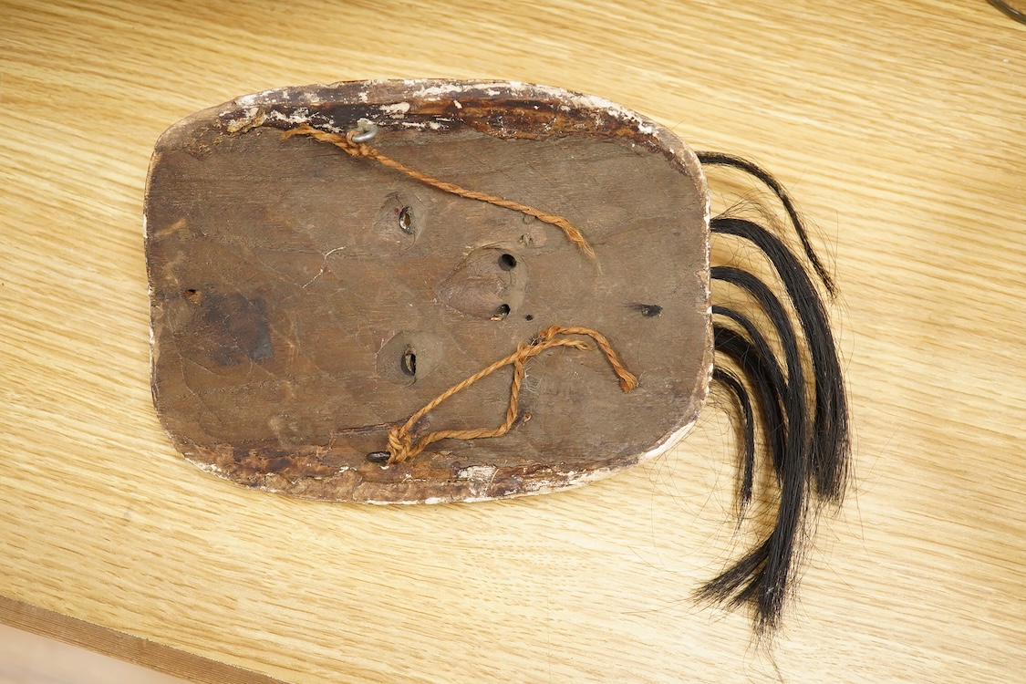 A wooden bowl with a decorative carved rim - 44cm wide across rim and an oriental carved and painted wooden face mask